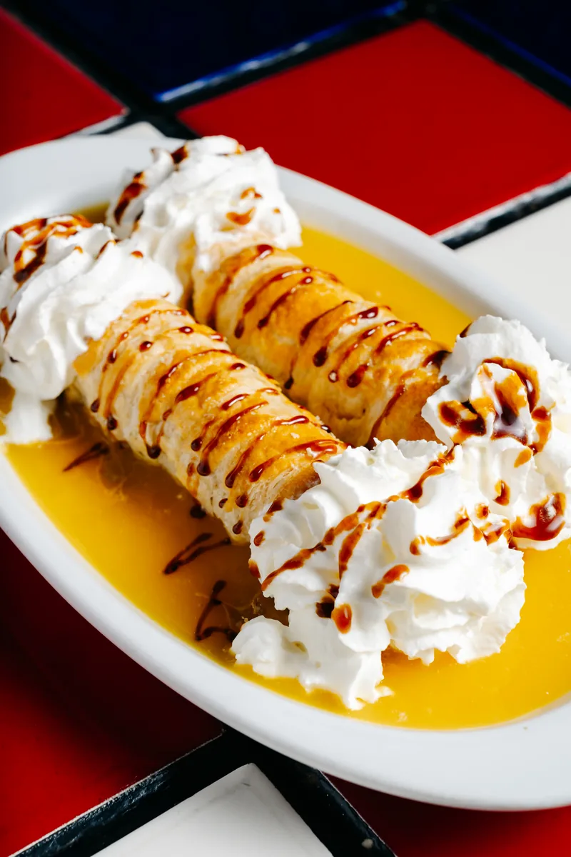 Canutillos rellenos de cajeta en cama de mango